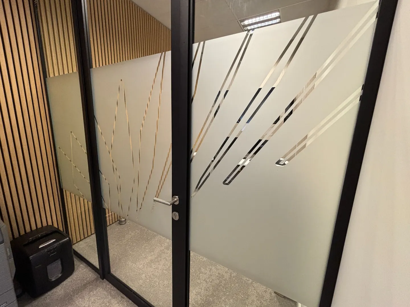 Glasfolie met grafisch lijnpatroon op een kantoorwand