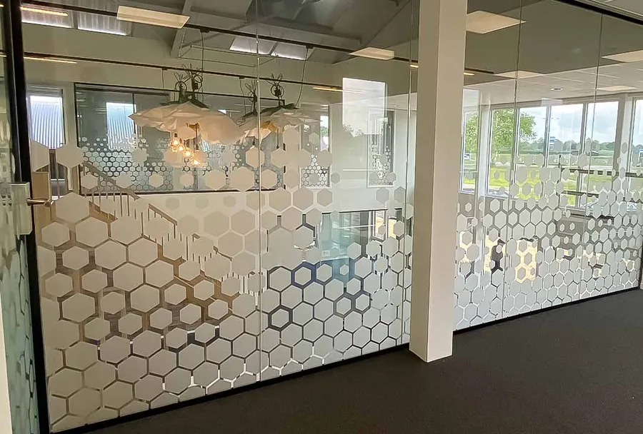 Decoratieve honingraatfolie op glazen kantoorwand